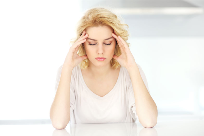 A picture of an adult woman having headache at home